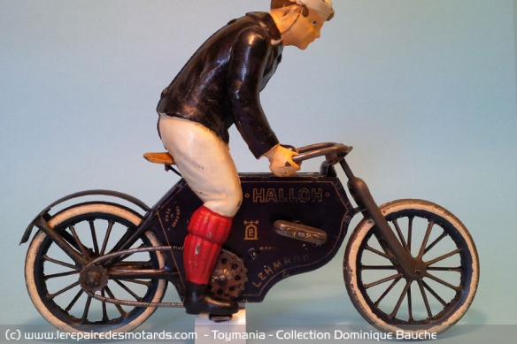 Moto mécanique à volant d'inertie « Halloh » de marque Lehmann (Allemagne). Fabriquée de 1914 à 1941. Longueur : 22 cm. Personnage peint. Cette moto fait partie d'une lignée de 5 modèles différents, tous de grande qualité de fabrication.