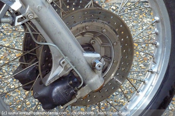 Les disques percés apparurent en 75. Censés mieux chasser l'eau en cas de pluie. A l'usage, on ne se rend pas compte de la différence en passant de l'une à l'autre. On notera les étriers placés derrière les fourreaux de fourche...