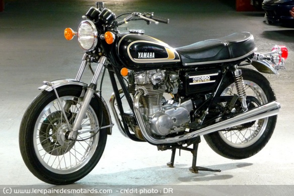 Yamaha 650 XS 1975, 447 modifiée. Nouveaux silencieux d'échappement, étriers placés derrière la fourche, elle-même retouchée. Chasse remaniée